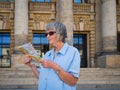 Portrait of a senior woman tourist with map