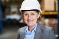 Senior woman warehouse manager or supervisor with white helmet. Royalty Free Stock Photo