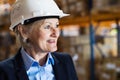 Senior woman warehouse manager or supervisor with white helmet. Royalty Free Stock Photo