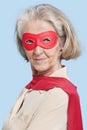 Portrait of senior woman wearing superhero costume against blue background