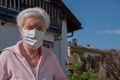 Senior woman with face mask in the garden