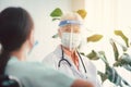 Portrait of senior woman doctor wearing face shield and consulting with women patient at room in hospital. Healthcare concept Royalty Free Stock Photo