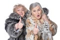 Portrait of senior women in fur coats with thumbs up Royalty Free Stock Photo
