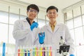 Portrait of senior and young doctor scientist wearing safty glasses and blue rubber gloves in working laboratory