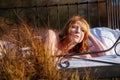 Portrait of an sensual, attractive, content, young, sexy redhead woman lying relaxed in bed, enjoying the nature in the orange Royalty Free Stock Photo