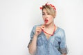 Portrait of sensual beautiful young woman in casual blue denim shirt with makeup and red headband standing with eyeglasses on her Royalty Free Stock Photo