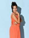 Portrait of sensual charming brunette woman wearing greek inspired dress coral color and gold head ring headband