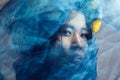 Portrait of sensual gorgeous asian woman looking at camera through blue veil on face Royalty Free Stock Photo