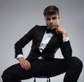 Portrait of sensual pensive young man in tuxedo sitting Royalty Free Stock Photo