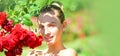 Portrait of sensual woman in spring background. Banner for website header. Happy girl in a garden with red roses