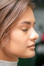 Portrait of a sensual young caucasian woman with closed eyes showing makeup tan on her face and hairstyle in a beauty Royalty Free Stock Photo