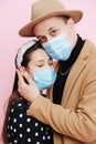 Portrait of a sensual young couple in love standing close, wearing medical masks