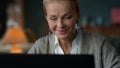 Portrait of sentimental old woman looking computer screen in luxury interior.