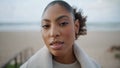 Portrait serene african american woman look camera at blurred ocean background.