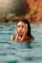 Portrait of serene looking attractive young black female posing in bikini in water. African model posing in the sea
