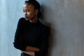 Portrait of a serious african or black american woman with arms folded standing over gray background and looking away Royalty Free Stock Photo