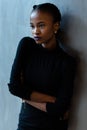 Portrait of a serious african or black american woman with arms folded standing over gray background and looking away Royalty Free Stock Photo