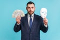 Portrait of serious bearded businessman in official style suit holding in hands dollars banknotes