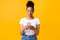 Focused afro girl using cell phone at studio Royalty Free Stock Photo