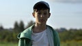 Portrait of a serious boy in a cap close-up looking at the camera, outdoors Royalty Free Stock Photo