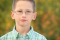 Portrait of serious boy with glasses in park Royalty Free Stock Photo