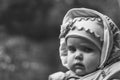 Portrait of serious brooding eleven month old baby girl on natural background with copy space