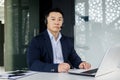 Portrait of serious businessman inside office, asian man with headset phone thinking looking at camera, man working Royalty Free Stock Photo