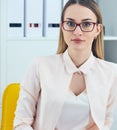 Portrait of young serious businesswoman looking at the camera while using laptop in office. Royalty Free Stock Photo