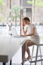 Portrait of serious businesswoman working on laptop while sitting in modern office. Royalty Free Stock Photo