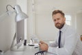 Portrait of a serious busy business man bearded sitting at a table with computers in the office.