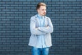 Portrait of serious calm handsome young blonde man in casual style standing with crossed arms and looking away with relaxed face Royalty Free Stock Photo