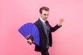 Portrait of serious concentrated young magician showing magic trick, performance. indoor studio shot isolated on pink background Royalty Free Stock Photo