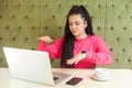 Portrait of serious concentration blind young woman with black dreadlocks hairstyle in pink blouse are sitting in cafe and