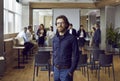 Portrait of serious confident business man standing in office against background of his office team. Royalty Free Stock Photo