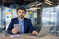 Portrait of serious confident businessman at workplace inside office, mature man looking thinkingly at camera, boss in Royalty Free Stock Photo