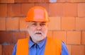 Portrait of serious construction worker in safety vest and helmet. Bearded architect builder in protective hard hat on Royalty Free Stock Photo