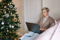 Portrait of serious elegant middle-aged woman remote working or shopping online buying new year presents sitting on Royalty Free Stock Photo