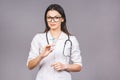 Portrait of serious female doctor in medical mask holding syringe for injection isolated on grey background Royalty Free Stock Photo