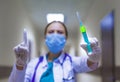 Portrait of serious female medical doctor or nurse with stethoscope in the hospital corridor and showing attention sign. Royalty Free Stock Photo