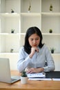 A portrait of a serious and focused Asian businesswoman examining business financial reports Royalty Free Stock Photo