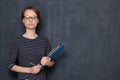 Portrait of serious focused girl with glasses, holding folders and pen Royalty Free Stock Photo