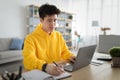 Focused asian man working on laptop and writing Royalty Free Stock Photo