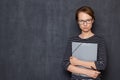 Portrait of serious focused young woman holding folder and pen Royalty Free Stock Photo