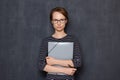 Portrait of serious focused young woman holding folder and pen Royalty Free Stock Photo