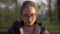 Portrait of serious girl sitting in park. Teenager girl feeling sad outdoors. Royalty Free Stock Photo