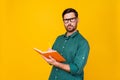 Portrait of serious gloomy man wear stylish shirt in glasses write in copybook on lecture in college isolated on yellow Royalty Free Stock Photo