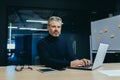 Portrait of serious gray haired boss, man looking at camera thinking, mature businessman inside office working at desk Royalty Free Stock Photo