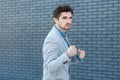 Portrait of serious handsome bearded man in casual style standing in boxing gesture and looking at camera with anger face in Royalty Free Stock Photo