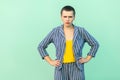 Portrait of serious handsome beautiful short hair young stylish woman in casual striped suit standing with hands on wasit and