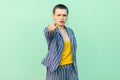 Portrait of serious handsome beautiful short hair young stylish woman in casual striped suit standing looking and blaming at